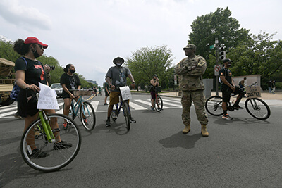 Army Capt. Macharia Davis, an intelligence officer with the District of Columbia Army National Guard’s, Headquarters and Headquarters Detachment, 74th Troop Command, talks with individuals taking part in one of many demonstrations and protests in Washington, D.C., Saturday, June 6.